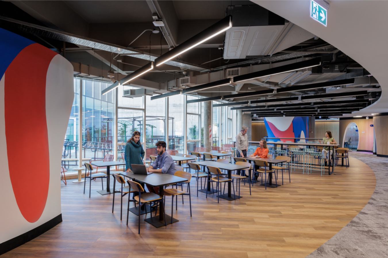 Uala Offices 2024 - Vibrant office cafe with wood flooring and branded wall graphics - Contract Workplaces.jpg